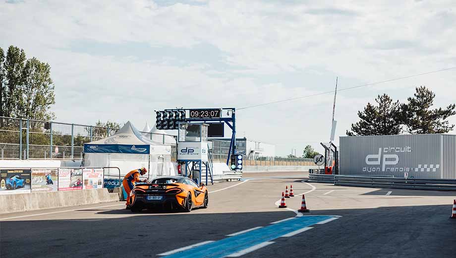 Mclaren in the Pitlane during a GP Days Open Pitlane Track Day at the Circuit Dijon Prenois in France. The driver is speaking to a track marshall before getting on the race track.